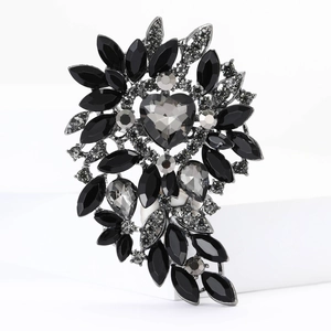 Detailed close-up of alloy floral brooch with heart-shaped glass crystals and black stones