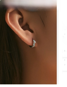 Macro view of mint green enamel butterfly earrings on ear with silver accents