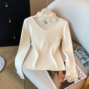 Détails d'un pull en maille blanche avec col et poignets en dentelle de style français
