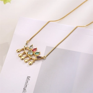 Detail of gold chain necklace with colorful zircon evil eye pendant and metal fringe