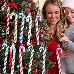 Macro detail of striped candy cane ornaments hanging on a decorated Christmas tree