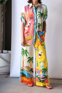 Close-up of vibrant tropical print and texture on summer shirt and wide-leg pants set
