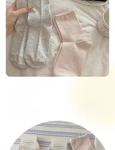 Close-up of soft cotton knit socks in pastel gray and pink with refined textures