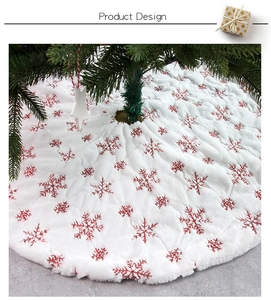 Detail of white plush Christmas tree skirt with red sequin snowflake embroidery