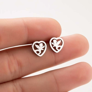 Détail macro de boucles d'oreilles cœur évidé avec motif ange tenues à la main