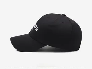 Side view of black baseball cap featuring white Brooklyn embroidery and cotton twill texture
