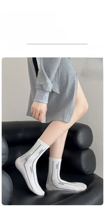 Détail de chaussettes en coton blanc avec rayures grises et motif de lettres CHERRY