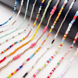 Detail of colorful glass seed bead chains for glasses and masks with golden accents