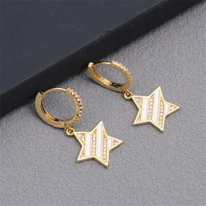 Detailed view of gold star hoop earrings with micro-pave crystals and white enamel