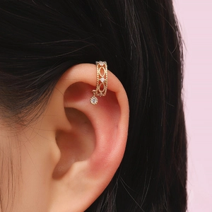 Detailed view of a hollow vintage gold ear cuff with sparkling zircon pendants