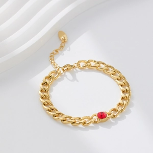 Close-up of 18k gold plated Cuban chain with a round red gemstone and extender link