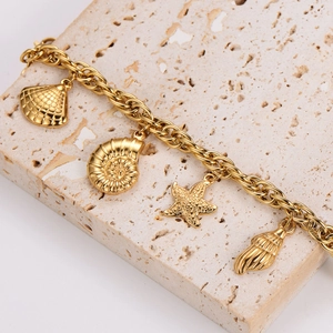 Gold stainless steel ocean charm bracelet featuring starfish and seashell pendants