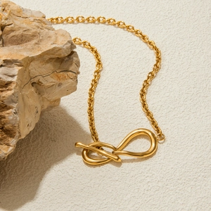 Détail du pendentif nœud en or 18K sur chaîne acier inoxydable avec fermoir OT