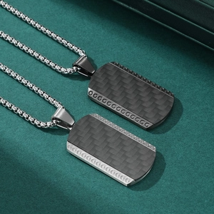 Men's titanium steel pendant with carbon fiber inlay on a textured green background