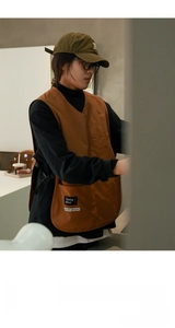 Detail of waterproof brown barista apron showing large utility pockets and durable fabric