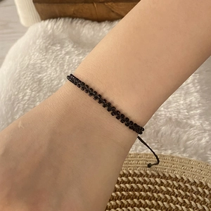 Detailed view of a handwoven black seed bead bracelet worn on a wrist for daily use