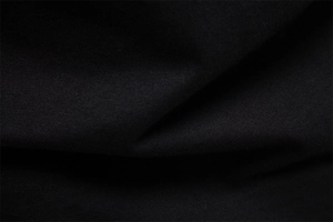 Macro view of black cotton fabric showing the fine knitted texture and soft finish