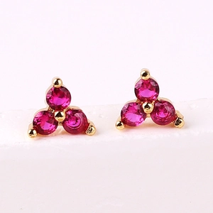 Macro detail of gold-plated cluster earrings featuring three purple zircon stones