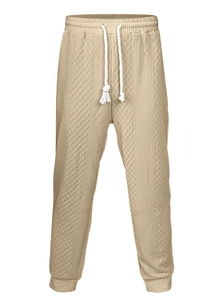 Detail view of beige leisure trousers with waffle knit texture and cotton drawstring