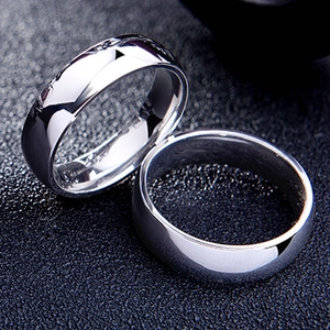 Pair of 6mm minimalist polished stainless steel couple rings on a dark textured background