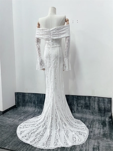 Rear view of white lace off-shoulder wedding gown featuring an elegant long train