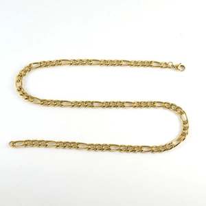 Macro shot of polished golden Figaro chain necklace with a classic 3:1 link pattern design