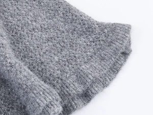 Détail de la texture en maille grise avec fibres de laine douces et bords volantés