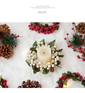 Close-up of Christmas candle ring with red berries, pine cones and snow decor