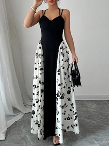 Élégante robe longue fleurie noir et blanc dos nu portée par un mannequin en intérieur