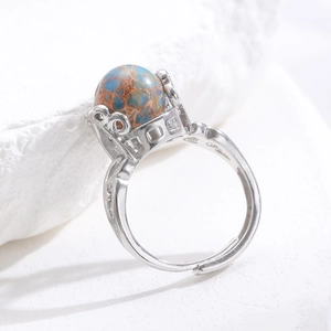 Makro-Detail eines silbernen Vintage-Rings mit blauem Kaiserstein auf weißem Stein