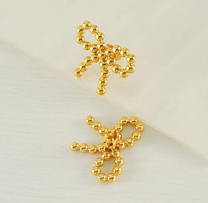 Detail of 18k gold plated stainless steel bow earrings with micro-bead texture design