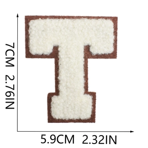 Detail of towel-embroidered letter T patch with white stitching on brown felt base