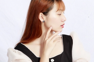 Elegant round disk stud earrings with black and silver floral pattern shown on model