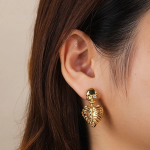 Golden skeleton heart earrings with rhinestones shown on model for a gothic style look