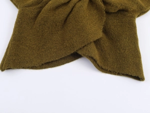 Gros plan sur un tricot vert mousse montrant la texture brossée douce et les détails