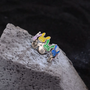 925 silver open ring with colorful enamel rabbit faces on textured gray rock background