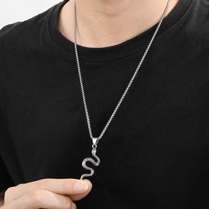 Macro detail of silver vintage snake pendant with textured scales on a metal chain