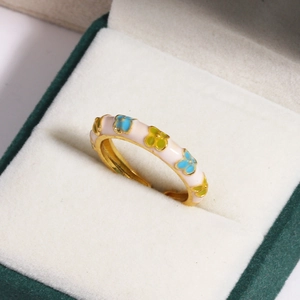 Macro shot of colorful enamel flower ring with pink, blue and yellow blossoms in a gift box