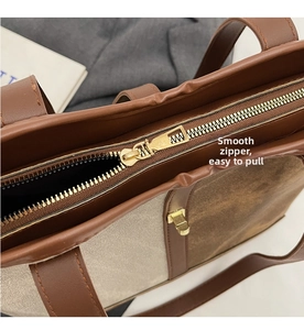 Detail of high-quality smooth gold metal zipper closure on a canvas tote bag
