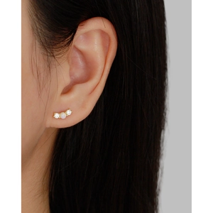 Close-up of S925 silver opal stud earrings with cubic zirconia on a model's ear