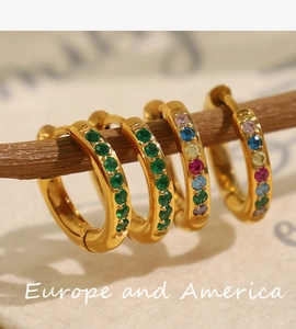 Detailed close-up of golden hoop earrings with vibrant multi-colored micro-pave gemstones