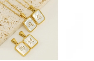 Détail de colliers zodiacaux en acier doré 18K avec incrustations en nacre blanche pure