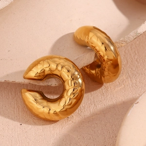 Vista macro degli orecchini a C placcati in oro 18K con texture pelle di serpente