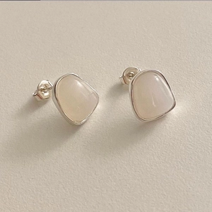 Macro view of irregular geometric 925 sterling silver earrings with opal-style stones
