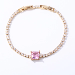Detailed macro view of gold tennis bracelet with pink square zirconia stones