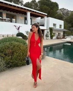 Détail de robe longue en maille rouge avec col en V, boutons et fente latérale haute