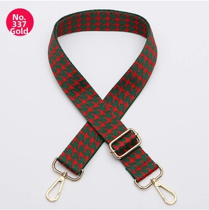 Detail of red and green houndstooth adjustable bag strap with golden metal swivel hooks
