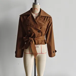 Détail d'un trench-coat marron à double boutonnage avec col à revers et ceinture à la taille