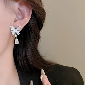 Macro detail of butterfly earring with silver base, shell inlay and zircon drop