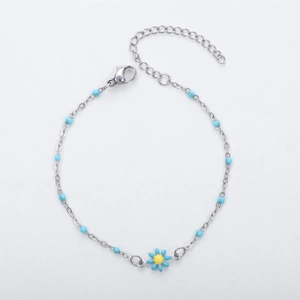 Detail of silver chain bracelet featuring blue enamel daisy charm and matching beads